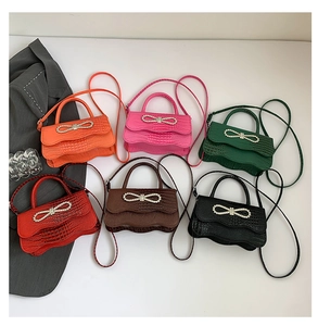 Top view of crocodile pattern crossbody bags in six colors with rhinestone bow detail