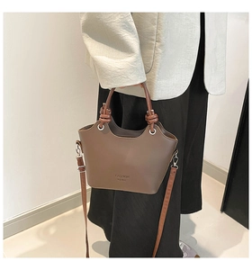 Brown leather bucket bag with fashion logo and decorative knot handle detail