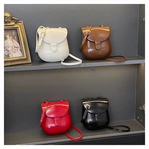 Mini horseshoe crossbody bags in four colors displayed on sleek studio shelves
