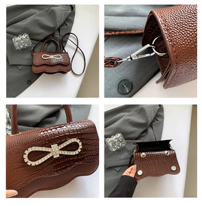 Detail view of brown crocodile texture mini bag with rhinestone bow and silver hardware