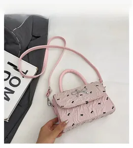 Vue détaillée du sac à bandoulière rose plissé avec imprimés nœuds et boucle métal