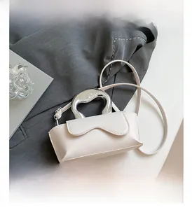 Detail view of cream PU mini bag with stylish wavy flap and silver metallic handle