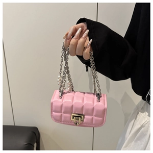 Detailed shot of pink quilted mini bag with silver chain strap and pearl accents