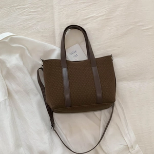 Flat lay of brown vintage bucket bag with leather straps and canvas texture detail