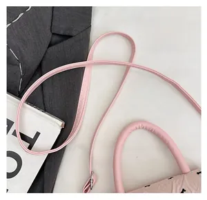 Détail de la bandoulière en cuir réglable et du tissu floral du sac rose bandoulière