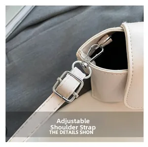 Detail of beige PU leather bag featuring adjustable strap and silver metal buckle