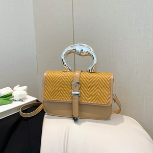 Fashionable beige leather crossbody bag with yellow straw weave flap and silver metal handle