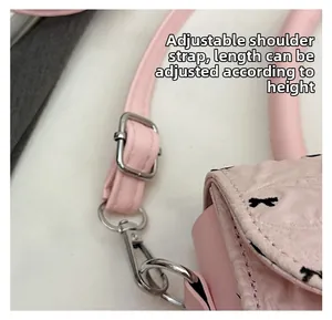 Détail de la bandoulière réglable en cuir rose avec boucle et fermoir en métal