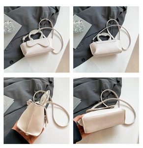 Detail view of cream white crossbody bag featuring unique silver hollow metal handle