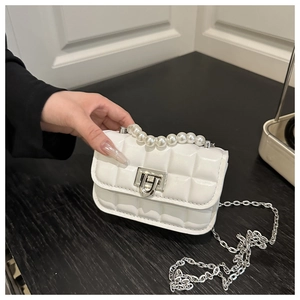 Close-up of white quilted mini bag featuring elegant pearl handle and silver chain strap