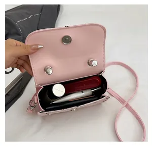 Vue intérieure du mini sac rose matelassé montrant l'espace cosmétique et le fermoir argenté