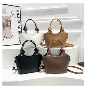 Detailed view of bucket bags in white, khaki, black, and brown with rope knot straps