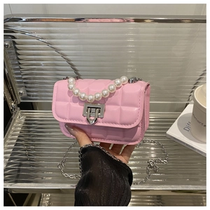 Detail of pink quilted leather mini bag with faux pearl handle and silver chain strap