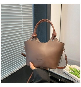 Detail view of brown PU leather bucket bag with unique twisted handle and logo print