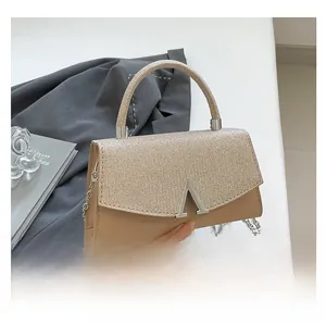 Detail showing glitter material contrast and silver A-shaped hardware on the handbag