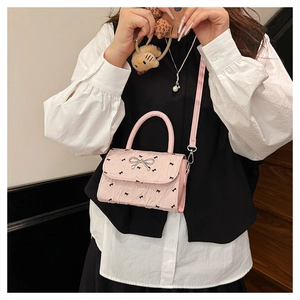 Sac à main rose avec nœud et bandoulière réglable porté par un mannequin pour style