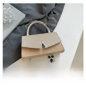 Detailed view of the beige chain bag showing leather texture and V-shaped silver metal buckle