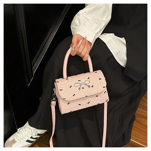 Détails du sac à main rose avec broderie de nœuds et fermoir argenté texturé