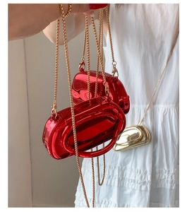 Detail of elegant metallic mini box bags with gold chains in red and gold finishes