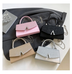 Detail of four glitter mini bags in pink black gold silver with V-shape metal buckles