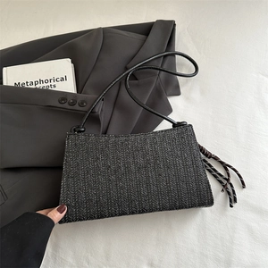 Bolso de hombro tejido negro minimalista con diseño de espiga y correa de cuero fino