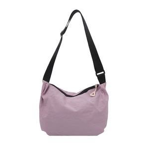 Lavender lightweight nylon dumpling crossbody bag with adjustable black strap and charm