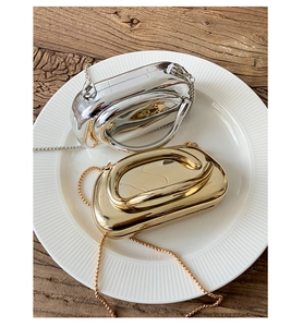 Close-up of elegant gold and silver acrylic box clutch bags with metallic chain straps