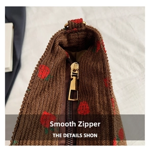 Macro detail of high-quality golden zipper on brown corduroy strawberry bucket bag
