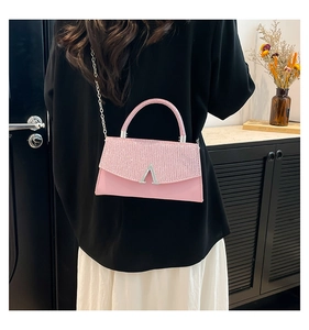 Detail of pink leather handbag with glittery flap and silver V-shaped metal buckle