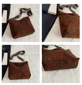 Detail of strawberry corduroy bucket bag with vintage ethnic embroidered wide strap