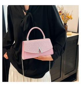 Detailed view of pink sequin shoulder bag with silver chain strap and V-shaped metal clasp