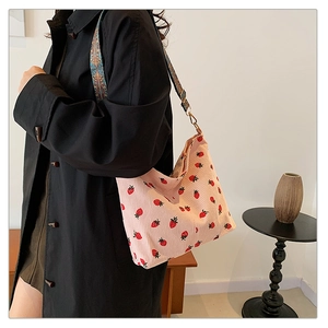 Side view of strawberry corduroy tote bag with colorful ethnic geometric wide shoulder strap