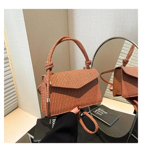 Macro shot of orange woven texture and V-shape flap on this elegant crossbody bag
