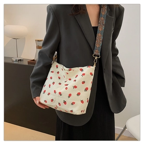 Close-up of strawberry print corduroy tote bag with ethnic style wide shoulder strap