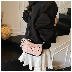 Pink heart pattern handbag with large lace pearl bow charm shown on steps