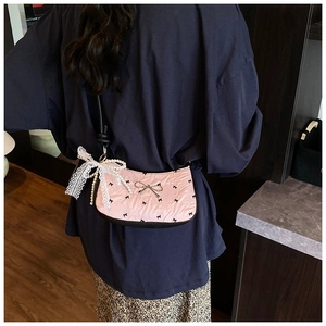 Pink shoulder bag with black bow print, white lace ribbon and pearl chain detail