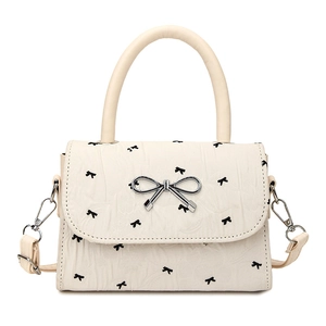 Petit sac carré crème avec motifs nœuds noirs et boucle en métal argenté