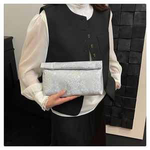 Detail of silver snake skin texture on a folding rectangular clutch bag for evening