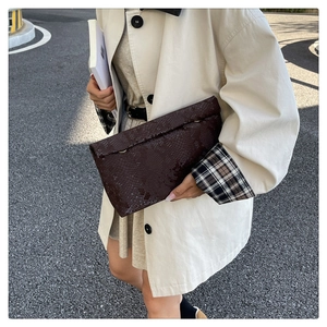 Detailed view of dark brown snakeskin texture on luxury envelope clutch bag