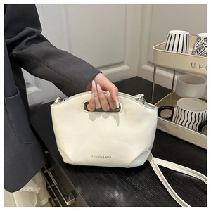 Détail du sac dumpling blanc crème avec poignée évidée et logo texte de mode