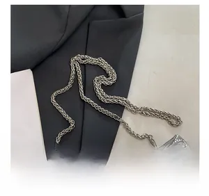 Detail of silver metallic chain strap on crocodile pattern leather handbag for women