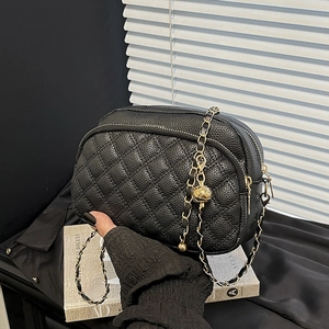 Sac bandoulière matelassé noir en cuir avec chaîne dorée et pendentif sphérique chic