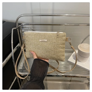 Detail shot of handwoven crossbody bag with light brown texture and white zipper