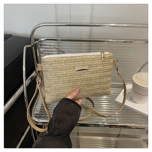 Detail of beige woven crossbody bag showing textured chevron pattern and golden zipper