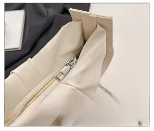 Detail of silver square metal zipper and lychee textured leather on cream cloud bag