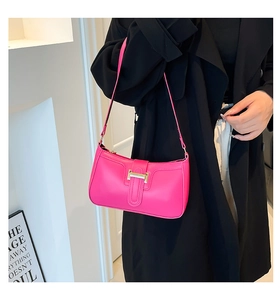 Detail of hot pink underarm bag with gold metal buckle and premium leather texture