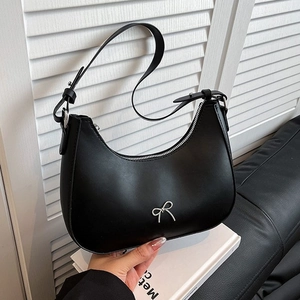 Fashionable black crescent shoulder bag with silver bow accent and adjustable strap