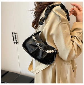 Détail du sac nuage noir plissé avec chaîne en perles et fleurs dorées pour femme