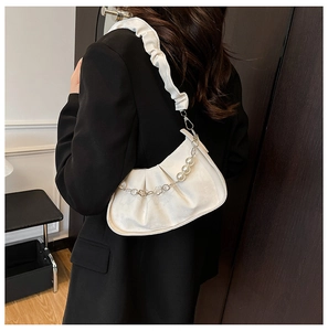 Détail du sac plissé blanc avec bandoulière à volants et chaîne décorative en perles