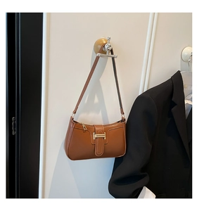 Detail of brown leather crescent shoulder bag with golden H buckle and stylish strap